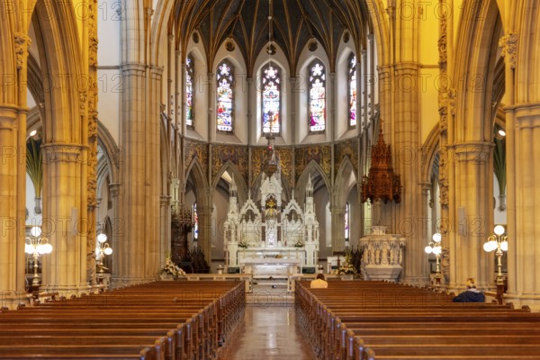 Magnificent interior of a church with a view of the altar and ornate Gothic arches under a warm light, Letterkenny