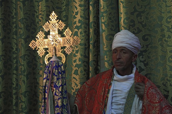 Lalibela, eastern group of rock-hewn churches, priest in the Bet Emmanuel, Emmanuel church, Ethiopian Orthodox cross, Ethiopia, Africa