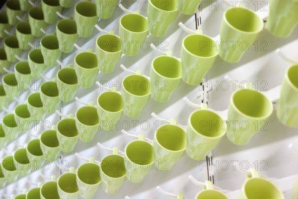 Green drinking cups hanging in an IKEA store create abstract pattern