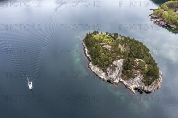 Aerial view topdown on island and sailing boat in the Lysefjord, just north of the Lysefjod bridge, Norway, Europe