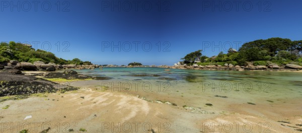 Beach with rocks and sand at the Plage Saint Guirec, with clear blue sky and colors as in the carribians