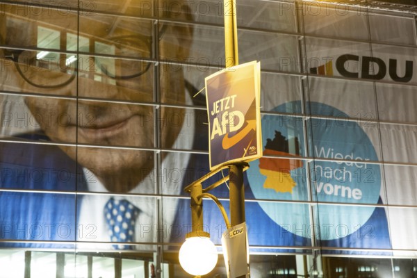 Banner with the likeness of Friedrich Merz behind an AfD election poster (now AfD) at the demonstration under the slogan Brandmauer statt Brandstifter / Asylrecht verteidigen in front of the Konrad-Adenauer-Haus, the party headquarters of the CDU, after a joint vote by the CDU and AfD in favour of a stricter migration policy introduced by party chairman Friedrich Merz. Berlin, 30.01.2025