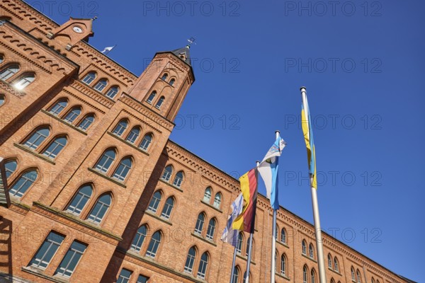 New Town Hall, Brick architecture, Architectural style neo-Gothic, Flagpoles, Israeli flag, German flag, Flag of the city of Celle, Ukrainian flag, Frog perspective, vertical, blue sky, cloudless, Street Am Französischen Garten, Celle, Lüneburg Heath, District of Celle, Lower Saxony, Germany, Europe
