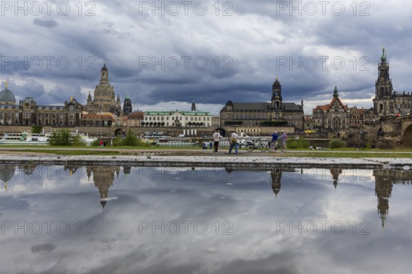 The Dresden silhouette with dark clouds behind the Church of Our Lady is reflected in a puddle on the Elbe cycle path, Elbe cycle path, Dresden, Saxony, Germany, Europe