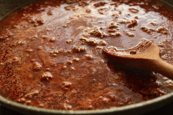 Cooking, bolognese sauce, in a frying pan, stirring with a wooden spoon, tomato meat sauce, homemade, no people