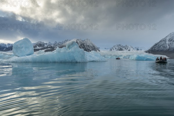 Dinghy with tourists, icebergs in front of glacier, -edge of Monacobreen, Liefdefjord, Woodfjord area, Spitsbergen Island, Svalbard and Jan Mayen archipelago, Norway, Europe