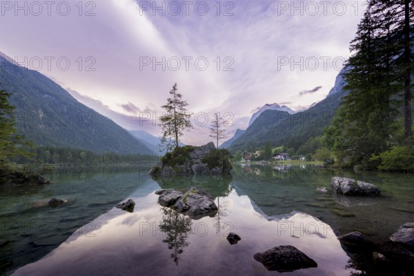 Hintersee with rocks and trees in the foreground, surrounded by mountains after sunset with dramatic cloudy sky, Ramsau, Berchtesgaden National Park, Berchtesgadener Land, Upper Bavaria, Bavaria, Germany, Europe