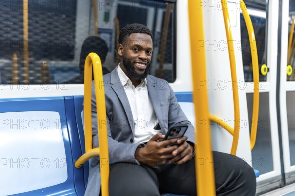 Young professional enjoying his commute, using a smartphone while traveling through the metro, exuding confidence and relaxation