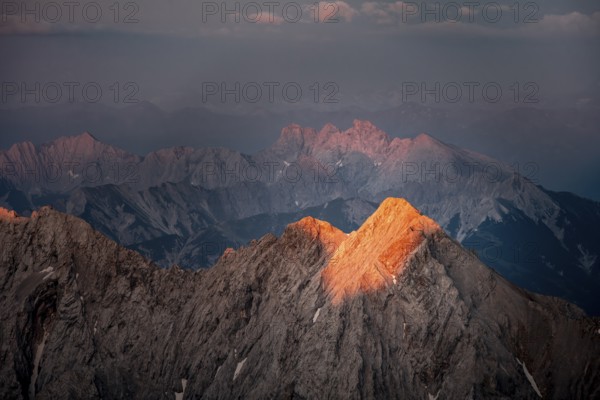 Last light on rocky mountains, Impressive rocky mountain landscape, Steep mountain ridge, Jubiläumsgrat with Alpspitze, Mountain panorama from the summit of the Zugspitze, Alpenglow at sunset, Northern Limestone Alps, Wetterstein range, Bavaria, Germany, Europe
