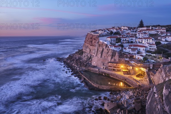 Scenic view of the seaside Azenhas do Mar fishing village on cliff on Atlantic ocean coast, Portugal in evening twilight dusk