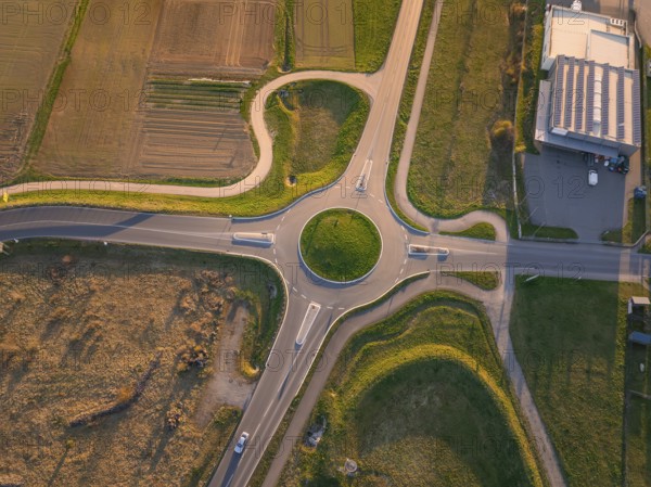 Aerial view of a roundabout surrounded by fields and buildings in the evening sun, Nagold, Black Forest, Germany, Europe