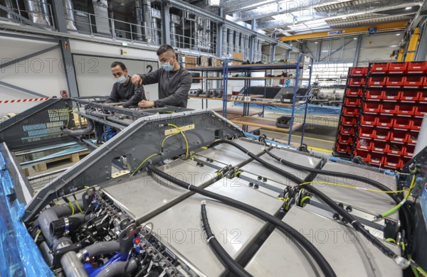 Herten, North Rhine-Westphalia, Germany, Cummins Hydrogenics fuel cell factory. Employees assemble fuel cell systems for Alstom's Coradia iLint hydrogen trains. The Coradia iLint is the world's first passenger train to be powered by a hydrogen fuel cell, which generates electrical energy for propulsion. Six fuel cell modules are installed on each train (right in the picture) . Note: The people pictured have given their verbal consent for publication in the press, Europe