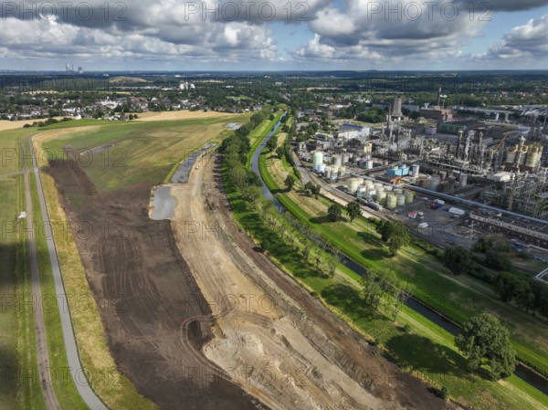 Oberhausen, North Rhine-Westphalia, Germany, renaturalisation of the Emscher in the Holtener Bruch. A new floodplain landscape for flood protection and biodiversity is being created here. On the right, OQ Chemicals plant Ruhrchemie. The Emscher, which is currently straightened, is given curves again and can meander through its new floodplain. The ecological reorganisation of the Emscher system consists of the construction of a central wastewater treatment system in the Ruhr area, the construction of sewers and the renaturation of the Emscher and its tributaries. Following the construction of a parallel sewer, the Emscher has been completely free of sewage since January 2022. The river was previously an open, above-ground combined sewer with rainwater and wastewater, Europe