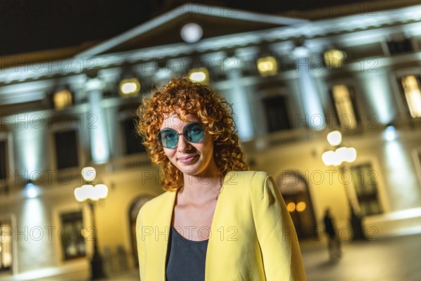 Millennial modern woman standing smiling at camera in the city at night