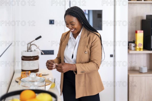 Smiling businesswoman preparing breakfast in hotel room during business trip, enjoying amenities and convenience