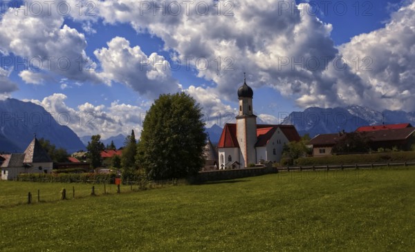 Idyllic village with church and mountains in the background under a blue sky, Wallgau, Bavaria, Germany, Europe