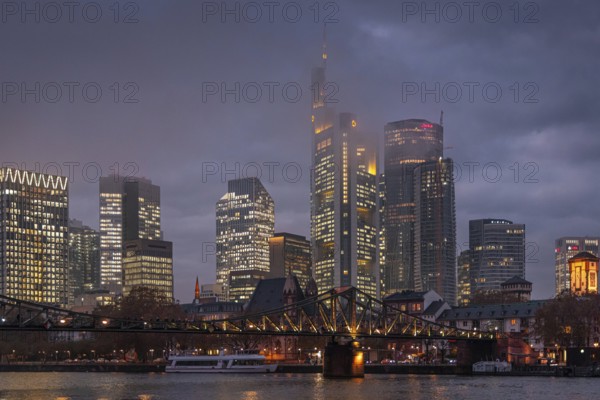 Low clouds envelop the shining towers of Frankfurt's banking skyline in the evening. Frankfurt am Main, Hesse, Germany, Europe