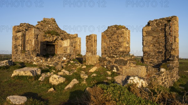 The ruins of Kenidjack Cliff Castle in the evening. Golden hour. Good weather, blue sky. Penzance, Cornwall, England, Great Britain