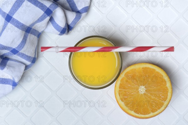 Orange juice in glass and orange, straw