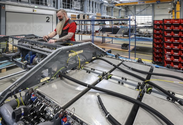 Herten, North Rhine-Westphalia, Germany, Cummins Hydrogenics fuel cell factory. An employee assembles fuel cell systems for Alstom's Coradia iLint hydrogen trains. The Coradia iLint is the world's first passenger train to be powered by a hydrogen fuel cell, which generates electrical energy for propulsion. Six fuel cell modules are installed in each train (right in the picture) . Note: The person pictured has given their verbal consent for publication in the press, Europe