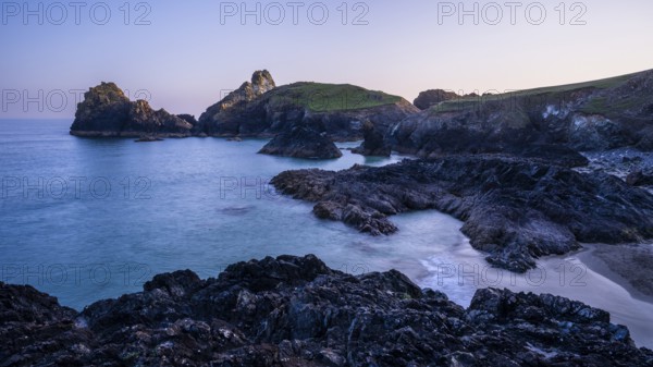 Kynance Cove with Asparagus Island, with sea, sandy beach and rocks in the evening at sunset. Coastal landscape. Long exposure. Good weather, blue sky. Kynance Cove, Lizard Peninsula, Cornwall, England, Great Britain