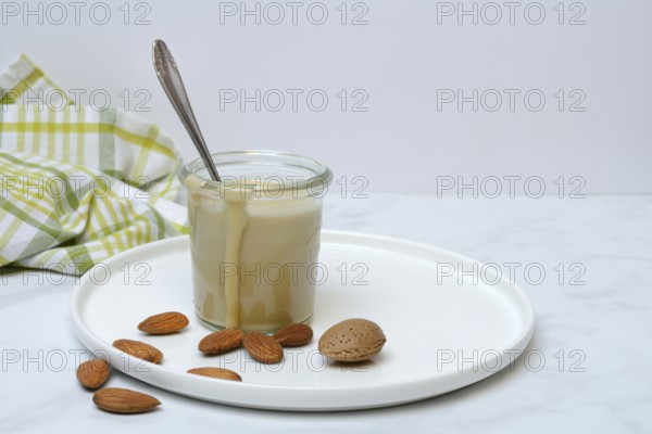 Almond cream in a jar and almonds
