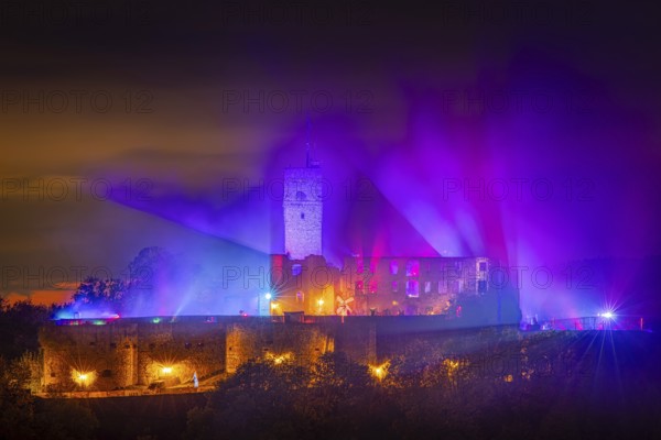 The castle in the town of Königstein im Taunus is brightly illuminated in the evening. From 18 October to 3 November 2024, the castle ruins will host the Frankenstein Halloween Festival under the motto A new Chapter of Fear, Taunus, Königstein, Hesse, Germany, Europe