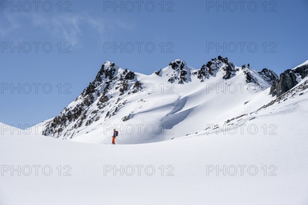Ski tourer on the descent, minimalist winter landscape, white snow and dark mountains on the Scalettahorn, Graubünden, Switzerland, Europe