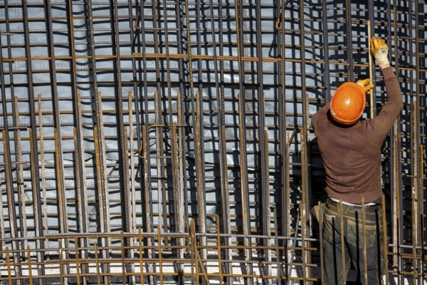 Essen, North Rhine-Westphalia, Germany, construction industry, construction workers working on a building site. Iron binder is a job title for construction workers who bind reinforcing mesh for the reinforcement of concrete parts. The meshes are prepared together with the formwork builder to form moulds, which are then filled with fresh concrete, Europe