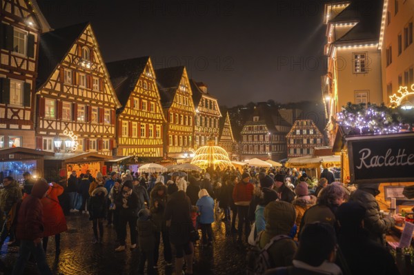 People gather on a Christmas-lit market square with historic buildings, Christmas market Calw, Black Forest, Germany, Europe