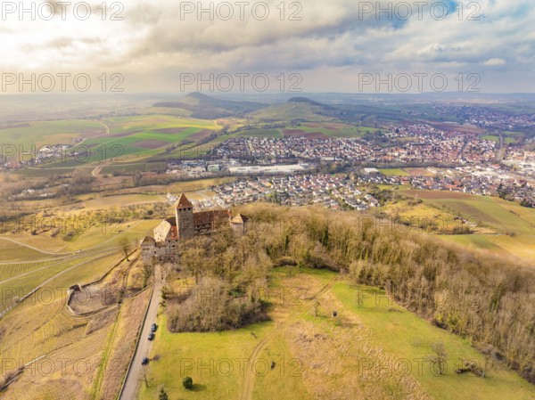 Aerial view of the castle with surrounding dense forests and a neighbouring village under a cloudy sky, Lichtenberg Castle, Oberstenfeld, Germany, Europe