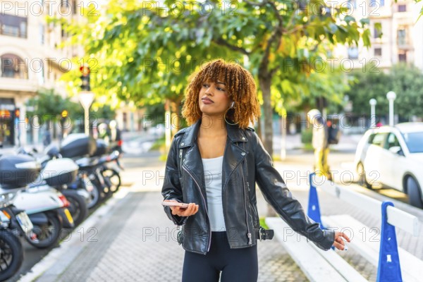 Latin woman enjoy the city walking and listening to music using phone