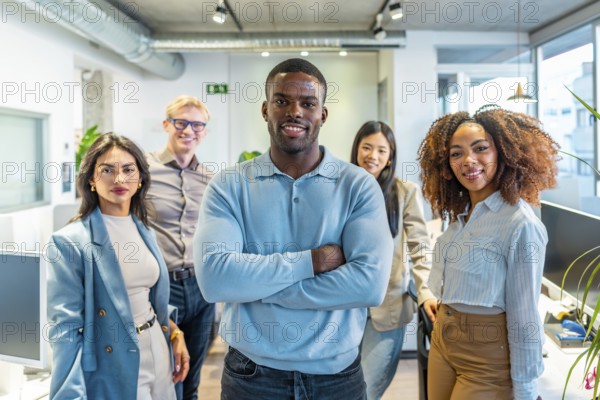 Diverse group of professionals standing together in a modern coworking space, showcasing teamwork and collaboration