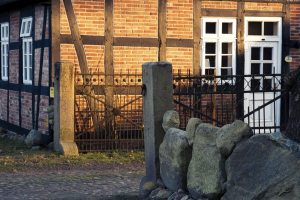 Evening light shines on a driveway and the façade of a half-timbered house, Otersen, Kirchlinteln, Verden, Aller Leine Valley, Lower Saxony, Germany, Europe