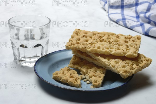 Crispbread on a plate and glass of water