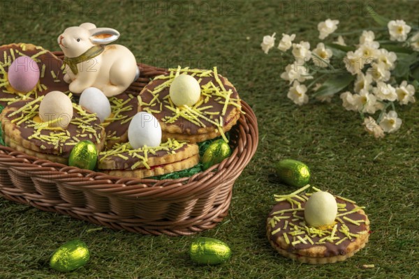 Easter biscuits in the shape of a nest with eggs in a basket in a meadow