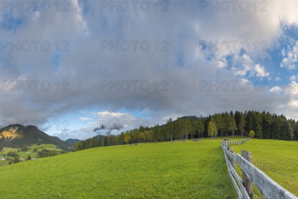 View along a wooden fence across a pasture to the mountains in the evening light, Dolomites, Odle Group, Sasso Putia Group, San Maddalena, Funes, Funes Valley, South Tyrol, Italy, Europe