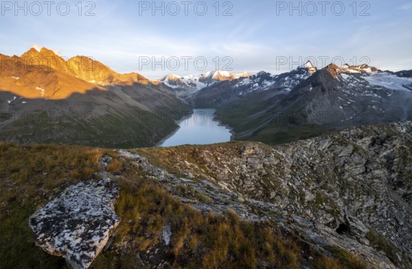 Picturesque mountain landscape at the summit Mont de la Blana at sunset, view of blue mountain lake, reservoir Lac des Dix and summit Mont Blanc de Cheilon with glacier, Hérémence, Valais, Western Alps, Switzerland, Europe