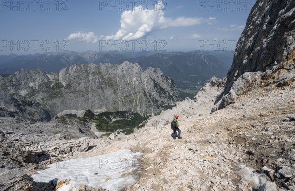 Mountaineer with helmet in rocky mountain landscape, descent to the Grieskarscharte, crossing the Jubiläumsgrat, Wetterstein range, Bavaria, Germany, Europe