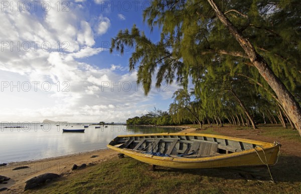 Yellow fishing boat on the beach at Calodyne, Gunner's Coin island in the background, Riviere du Rempart district, Mauritius, Africa