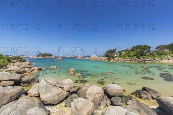 Beach with rocks and sand at the Plage Saint Guirec, with clear blue sky and colors as in the carribians