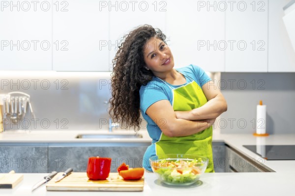 Portrait of a beauty female latin vlogger standing proud cooking healthy food at home