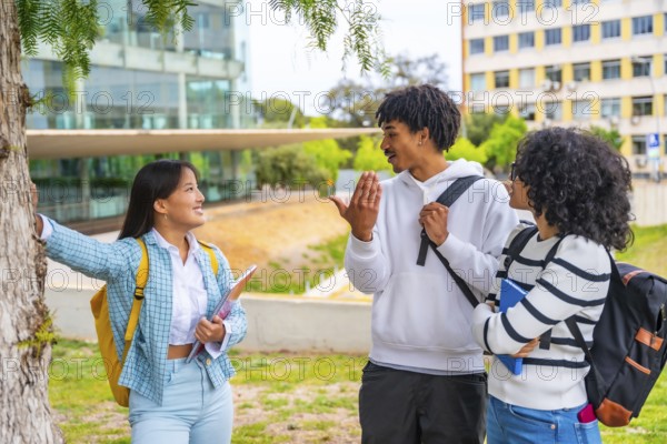 Three quarter length photo of three multi-ethnic friends talking standing together in the university campus