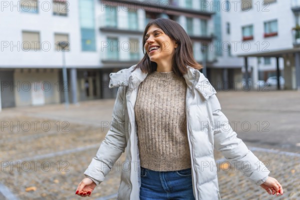 Caucasian happy woman wearing warm clothes enjoying dancing alone in the city