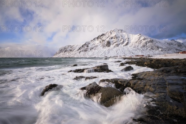 Beach of Norwegian sea on rocky coast in fjord on sunset in winter. Vareid beach, Lofoten islands, Norway, Europe