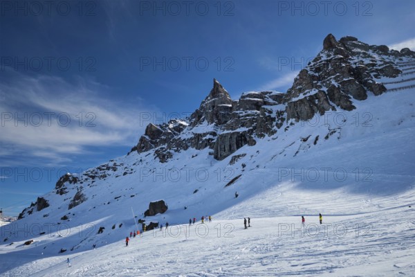 View of a ski resort piste with people skiing in Dolomites in Italy. Ski area Arabba. Arabba, Italy, Europe