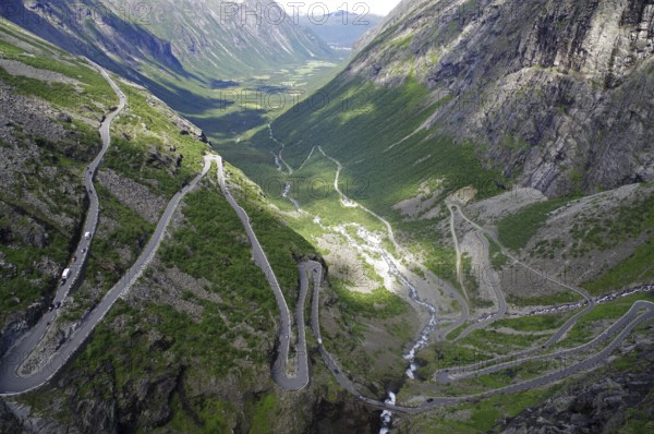 A winding road runs through a green valley between majestic mountains, Trollstigen, Andalsnes, Norway, Europe