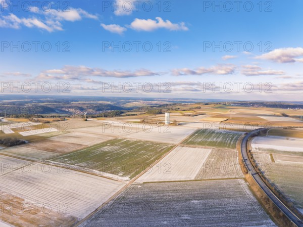 A sweeping view over snow-covered fields and a tower under a blue sky, district of Calw, Germany, Europe