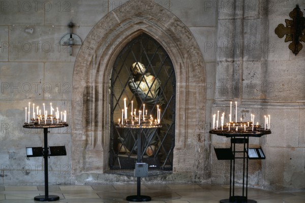 Sacrificial candles, behind them in the niche a figure of Jesus in the late Gothic hall church of St George, Dinkelsbühl, Bavaria, Germany, Europe