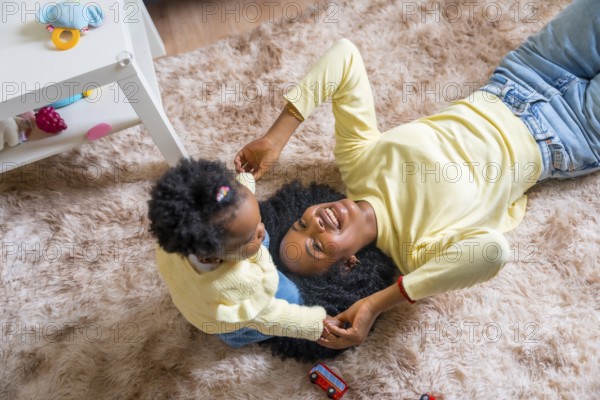 Top view of african mother and toddler playing on the floor